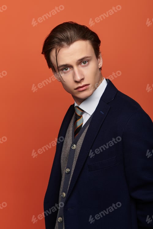 Preview: Stylish teenager posing confidently in a sleek outfit against an orange backdrop