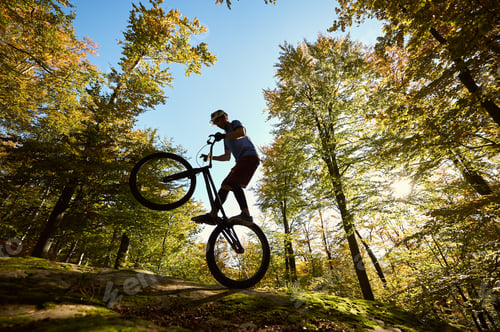 Preview: Sportsman cyclist balancing on back wheel on trial bicycle