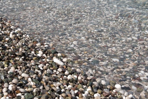 Preview: Small colorful pebbles and water. The beach is made of pebbles, the seashore, small colored