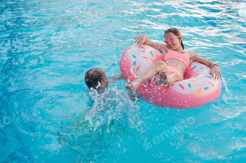 Preview: young girl with inflatable donut in swimming