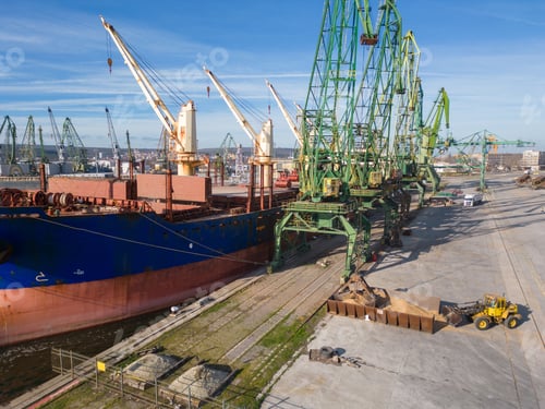 Preview: A bulk carrier ship loaded with grain is docked at a busy port, with workers and machinery seen in
