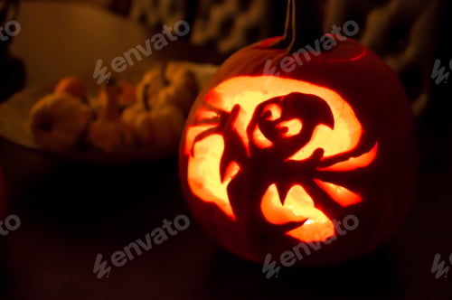 Preview: Happy cute jack o’lantern centerpiece indoors on table with a friendly ghost with smiling face and