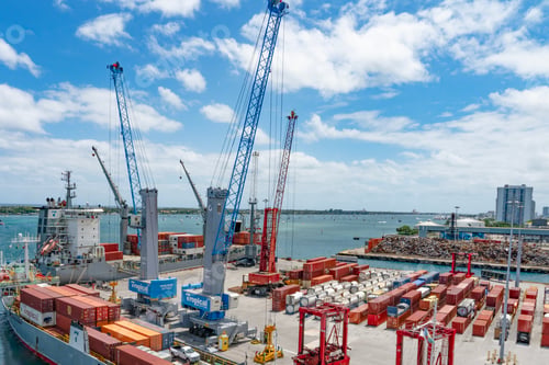Preview: Containers loading on to a cargo ship on a bright sunny day