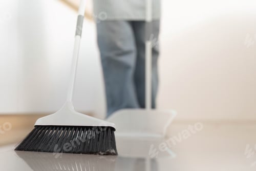 Preview: Floor Cleaning. Close-up of broom sweeping the floor, maintaining cleanliness.
