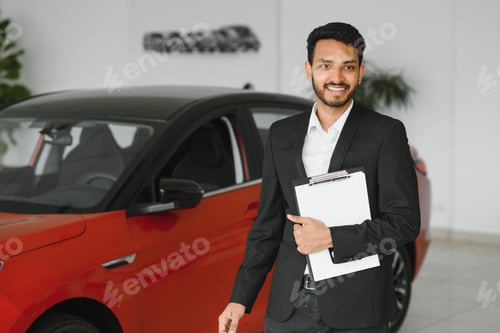 Preview: Successful indian businessman in a car dealership - sale of vehicles to customers.