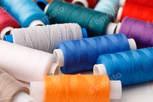 Preview: Close up of colored thread coils, thread spools background
