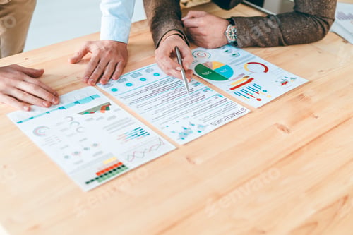 Preview: Young economist pointing at financial information while discussing strategies