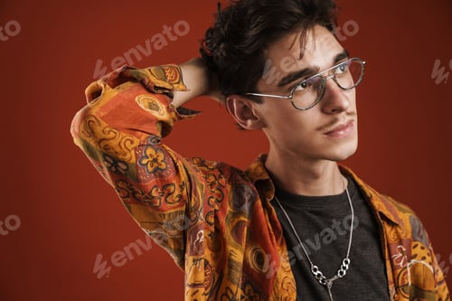 Preview: Pensive young hipster man standing isolated