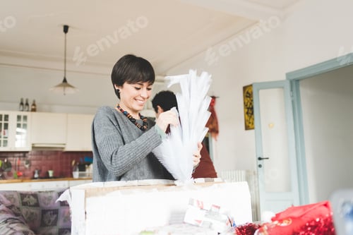 Preview: Young couple at home decorating xmas tree