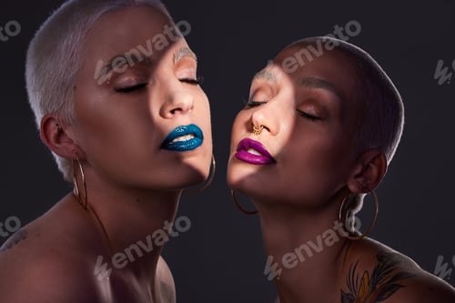 Preview: Say it with your lips. Studio shot of two beautiful young woman posing against a dark background.