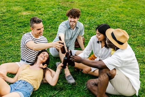 Preview: Happy young millennial group of diverse friends social gathering at city park