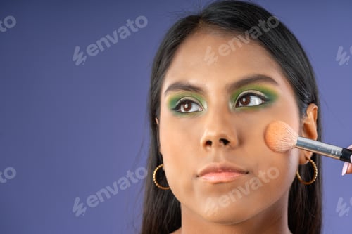 Preview: Young woman applying blush with a brush