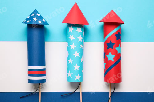 Preview: Firework rockets on color background, flat lay. Festive decor