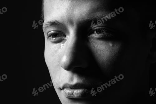 Preview: Sad man crying on dark background, closeup. Black and white effect