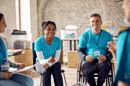 Preview: Black happy volunteer talking to her associates during a meeting at humanitarian aid center.