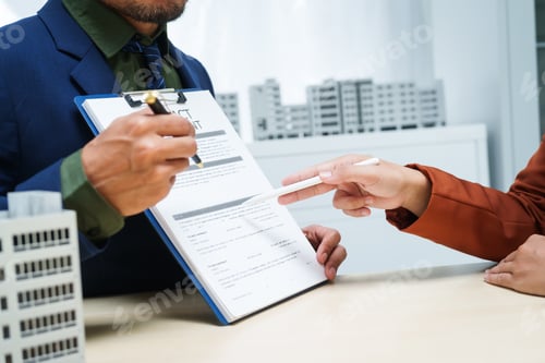 Preview: A businessman desk in a sales office sells a condo building customer.They agree to sign a contract