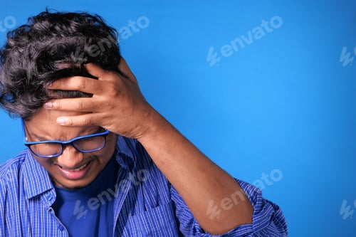 Preview: Close up of sad man covering face with hand.