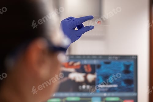 Preview: Science specialist looking at blood print for diagnose