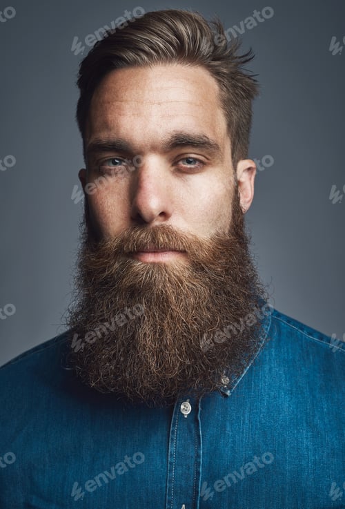 Preview: Confident young hipster standing against a gray background