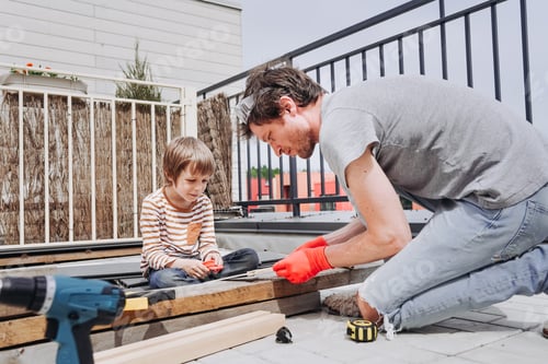 Preview: Dad and son make a wooden toy out of plywood on the roof of the house at one summer sunny day