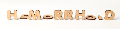 Preview: Concept of hemorrhoids with wooden letters on white background