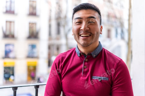 Preview: Portrait of a young Chinese man on a balcony at home smiling, everyday situation, apartment