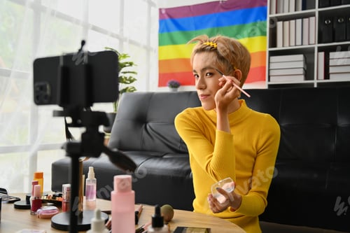 Preview: Charming young gay man blogger recording make up tutorial, live streaming at home.