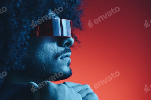 Vorschau: Porträt eines Modemannes mit lockigem Haar auf rotem Hintergrund mit stilvoller Brille, multikulturell