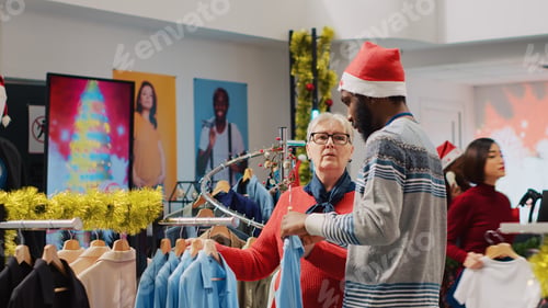 Preview: Clothing store worker helping woman