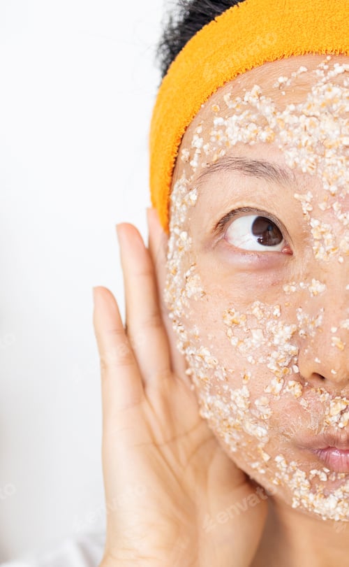 Preview: Portrait of a happy Asian woman using natural secrets for skin care (ingredients on the table: oats,