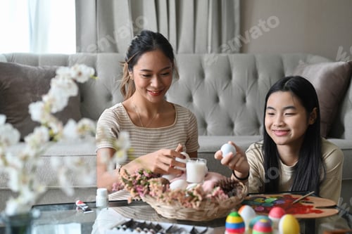 Preview: Easter eggs into wicker basket, preparing for Easter festival.