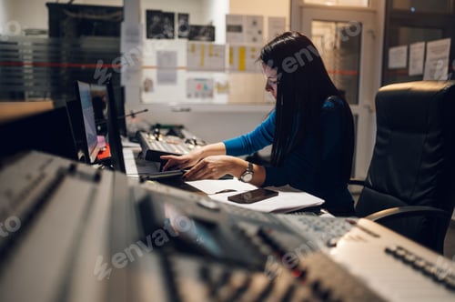 Preview: Middle aged woman using equipment in control room on a tv station