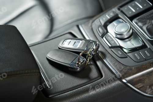 Preview: car keys lie on a closed glove box and an audio control unit