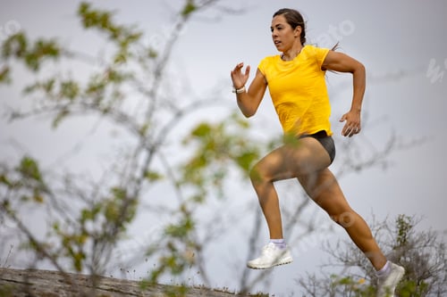 Preview: Confident Woman Sprinting On Mountain Against Sky