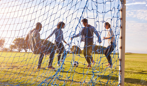 Preview: Two couples enjoy a game of football, seen through goal net