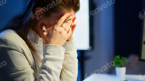 Preview: Close up of stressed woman with headache working late at night