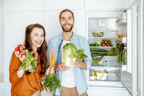 Preview: Young couple with healthy food at the kitchen