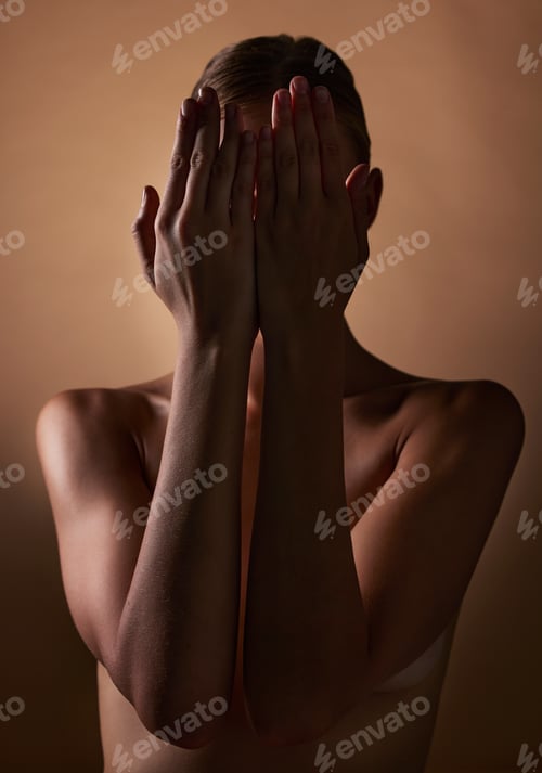 Preview: Woman, body and hands covering face on dark brown background in studio for creative aesthetic, art