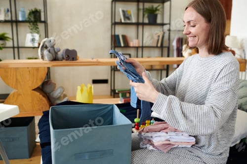 Preview: Mother packing baby clothes in box