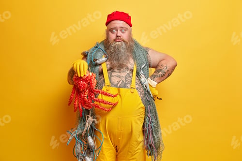 Preview: Obese bearded male sailor surprised to catch octopus instead of fish, looks with shocked sad express