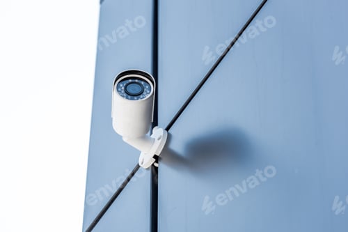 Preview: one security camera on blue wall of office building, security system concept