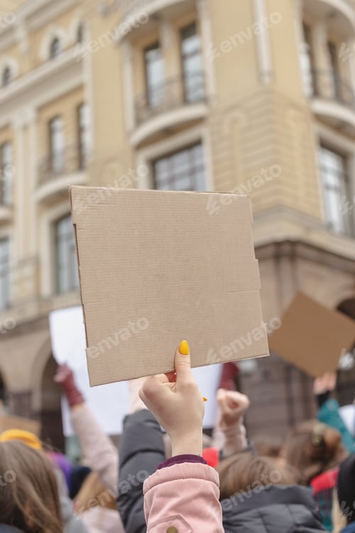 Preview: Woman holding poster in her hand against background of feminist protest. Copy space.