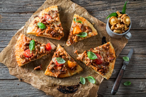 Preview: Top view of pizza with chanterelle mushrooms and basil