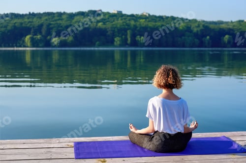 Preview: A young woman with curly hair doing yoga