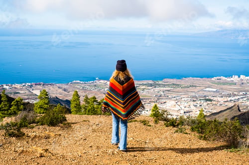 Preview: Back view of tourist and traveler walking to the cliff to admire the amazing coastline view. Travel