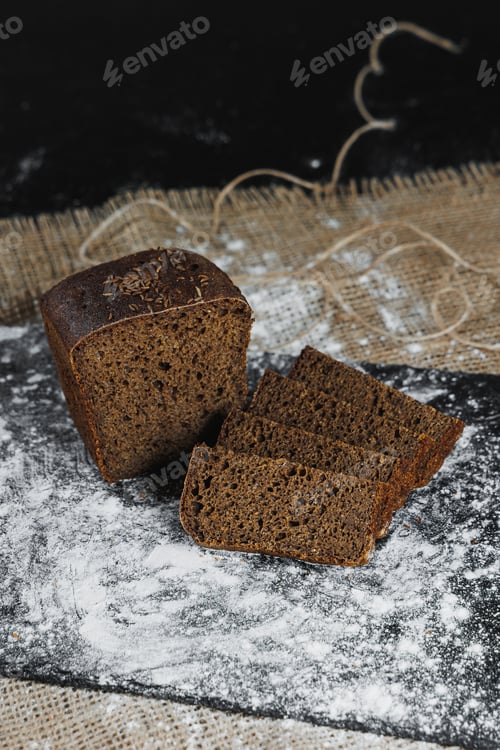 Preview: Slices of whole grain rye fresh bread on a dark background close up. Fresh home-baked sourdough