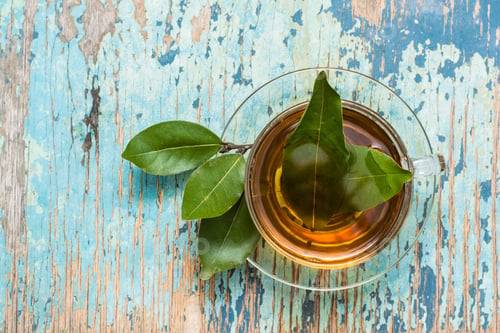 Preview: Fresh tea from bay leaf in a cup on a wooden rustic table. Top view