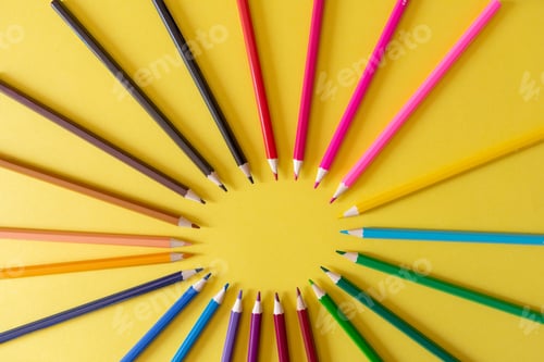 Preview: colourful pencils arranged in the shape of a circle on a yellow background