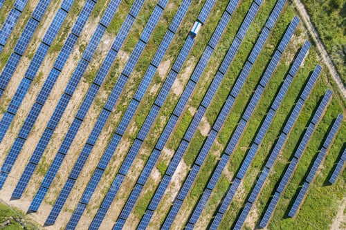 Preview: Aerial view of solar power plant on green field. Electric farm with panels for producing clean
