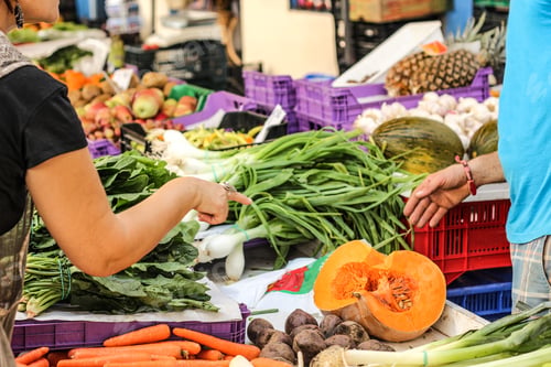 Preview: Selective focus shot of a female asking the price of melon in the street food market